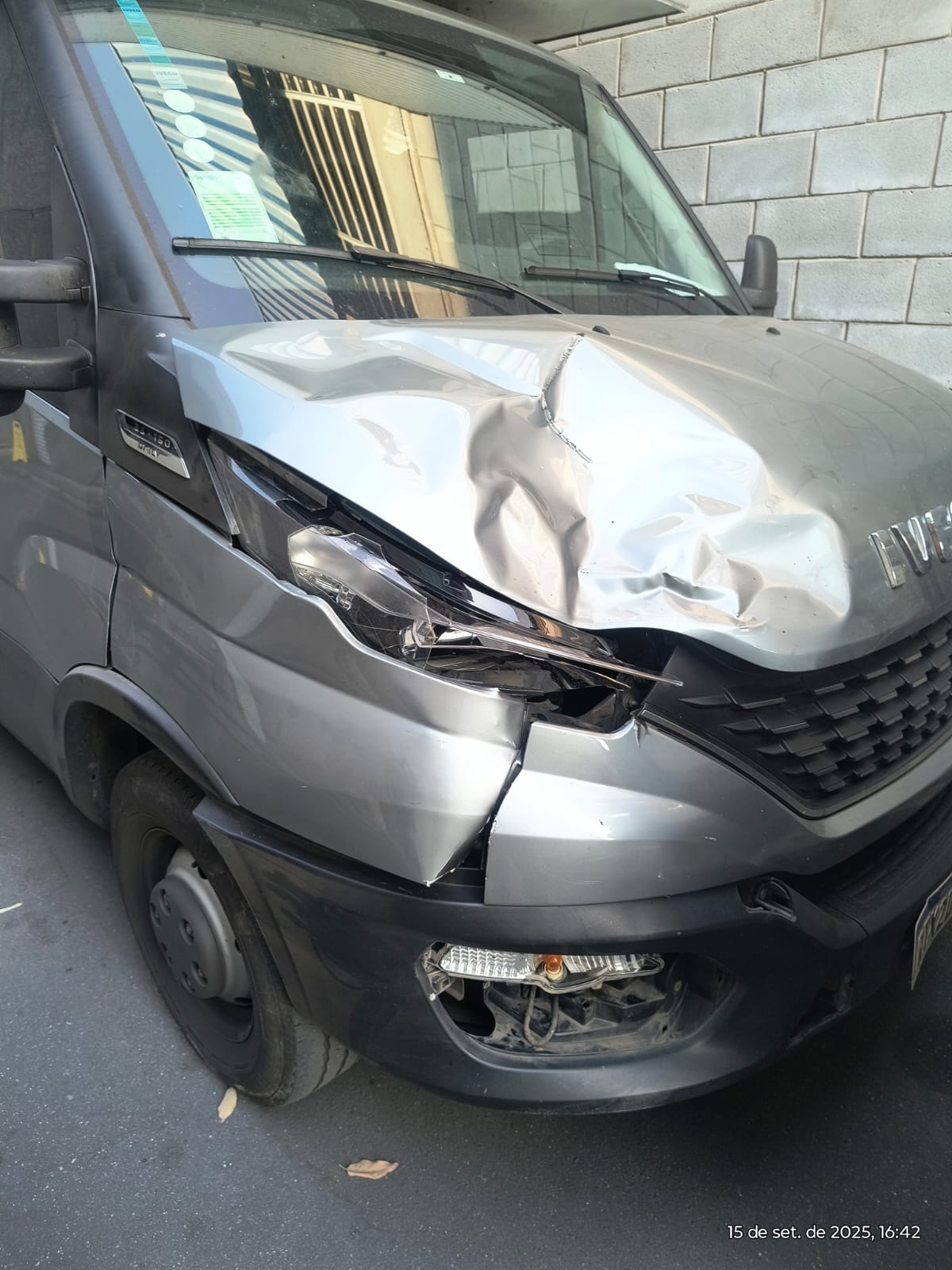 van IVECO prata com capô amassado e far dianteiro quebrado após colisão